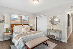 Bedroom featuring a closet and dark colored carpet