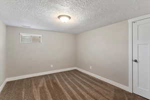 Spare room with a textured ceiling and carpet flooring