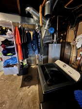 Utilities featuring a washer/dryer, water heater, and storage