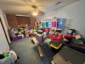 Rec room featuring brick wall and ceiling fan