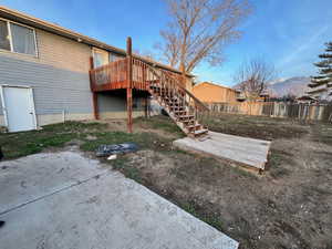 Back of house with stairway, a deck, and a patio area