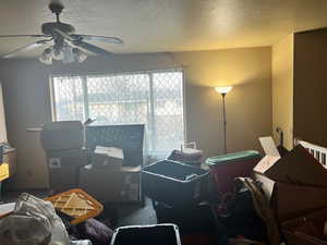 Living Room with a textured ceiling, a healthy amount of natural light, and a ceiling fan