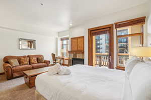 Bedroom featuring a tile fireplace and carpet