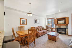 Dining room with a tiled fireplace and carpet flooring
