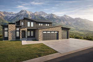 Contemporary house with stone siding, a mountain view, concrete driveway, and a front yard