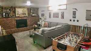 Living room featuring a textured ceiling, a fireplace, electric panel, and wooden walls