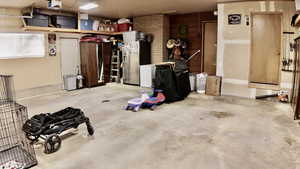 Garage featuring stainless steel fridge and a garage door opener