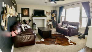 Living area with carpet flooring and ceiling fan