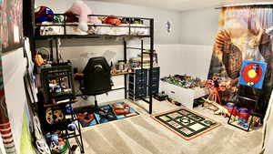 Bedroom featuring a wainscoted wall and carpet
