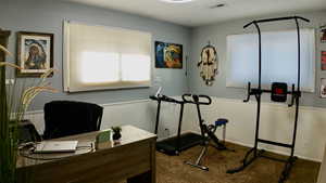 Office area with dark colored carpet and baseboards