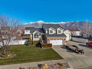 View of front facade with a mountain view, driveway, and brick siding