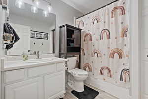 Full bathroom with vanity, light wood-style floors, shower / bathtub combination with curtain, and a textured ceiling