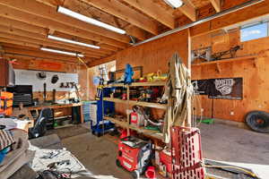 Miscellaneous room featuring a workshop area and unfinished concrete flooring