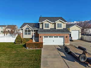 View of front of house featuring a garage, driveway, brick siding, and a shingled roof