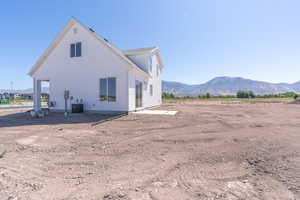 View of home's exterior featuring a mountain view and a central AC unit
