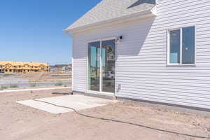 View of exterior entry featuring roof with shingles and a residential view