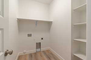 Laundry room with light wood finished floors, washer hookup, and electric dryer hookup