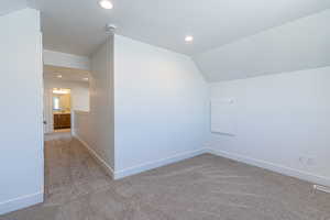 Additional living space featuring carpet, recessed lighting, and vaulted ceiling