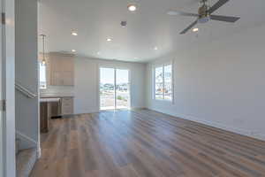 Unfurnished living room featuring stairs, a textured ceiling, light wood-style flooring, recessed lighting, and ceiling fan