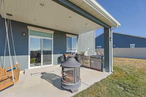 View of patio featuring exterior kitchen and a fire pit
