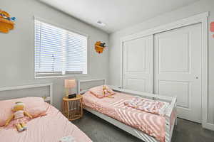 Carpeted bedroom with a closet