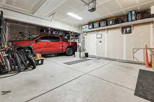 Garage with strapped water heater and a garage door opener