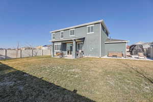 Rear view of house featuring a hot tub, a patio, stucco siding, and a fenced backyard