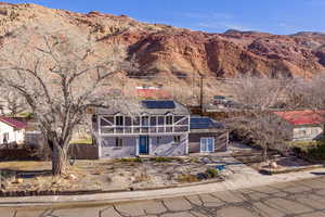 View of front of home with solar panels, a mountain view, brick & stucco exterior