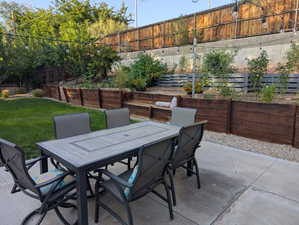 Fenced backyard featuring outdoor dining area and a patio