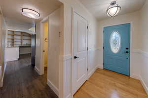 Entrance foyer with hardwood / wood flooring and wainscoting