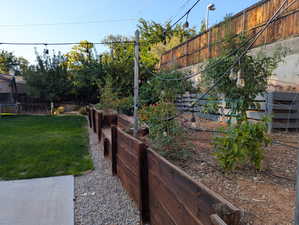 Fenced backyard featuring a vegetable garden