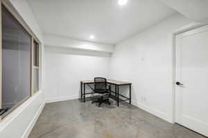 Home office featuring finished concrete floors and recessed lighting