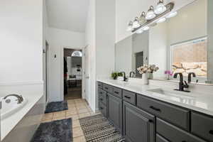 Full bathroom featuring double vanity, a bath, and light tile patterned floors