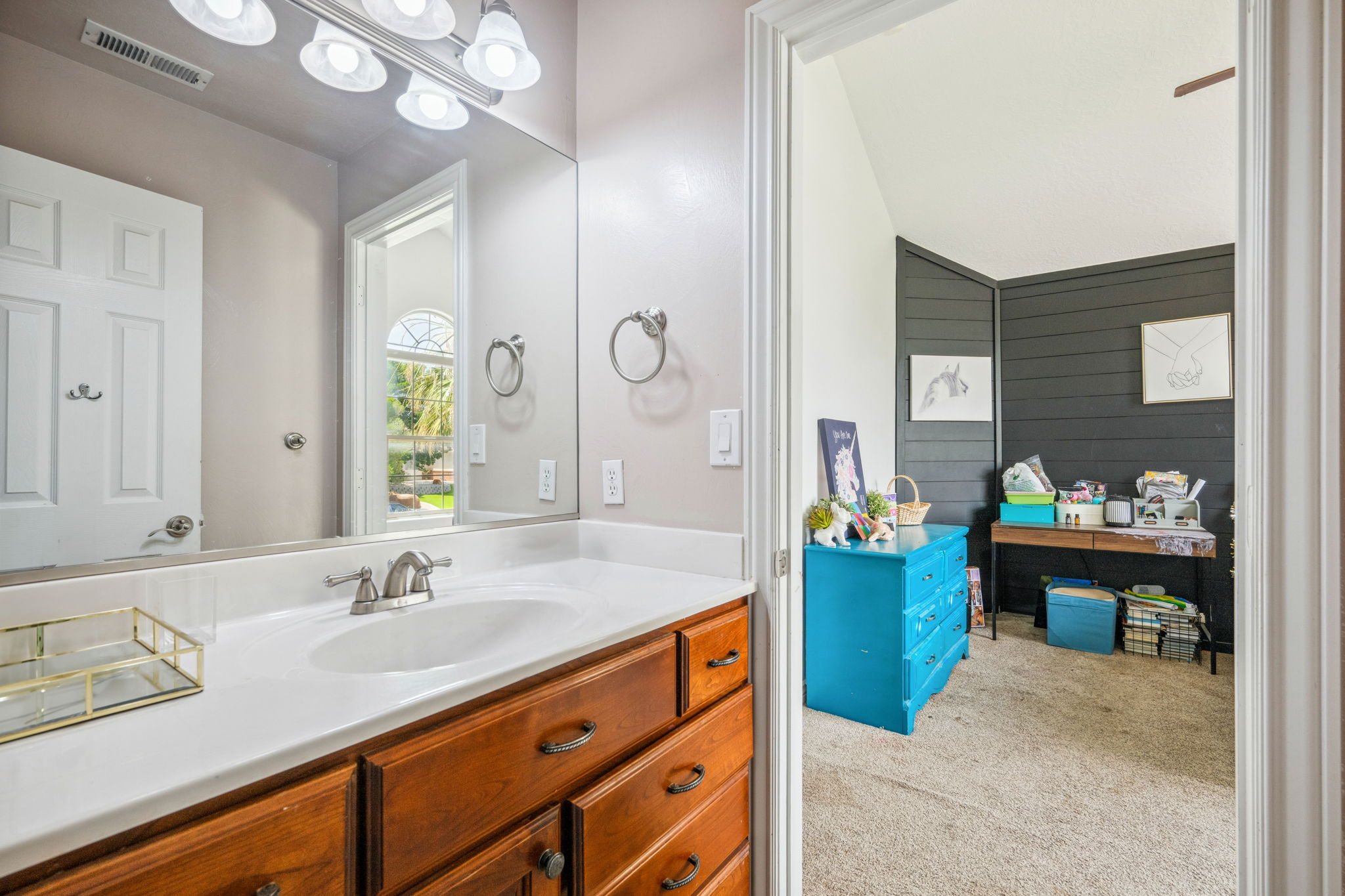 Bathroom featuring light colored carpet, vanity, and vaulted ceiling