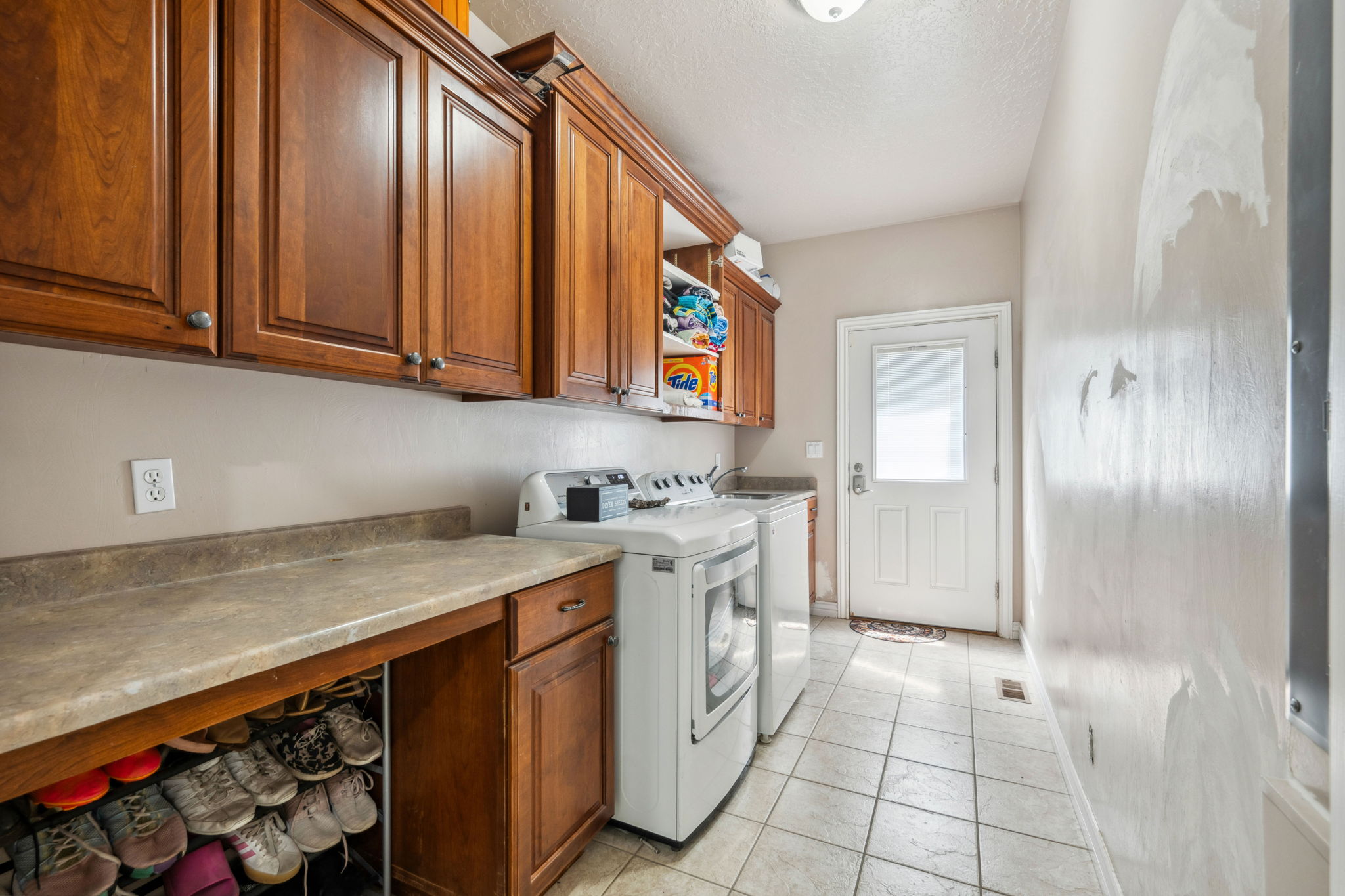 Laundry area featuring light tile patterned floors, independent washer and dryer, and a textured ceiling