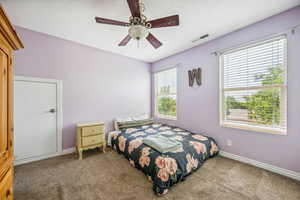 Bedroom featuring carpet floors, a ceiling fan, and a textured ceiling