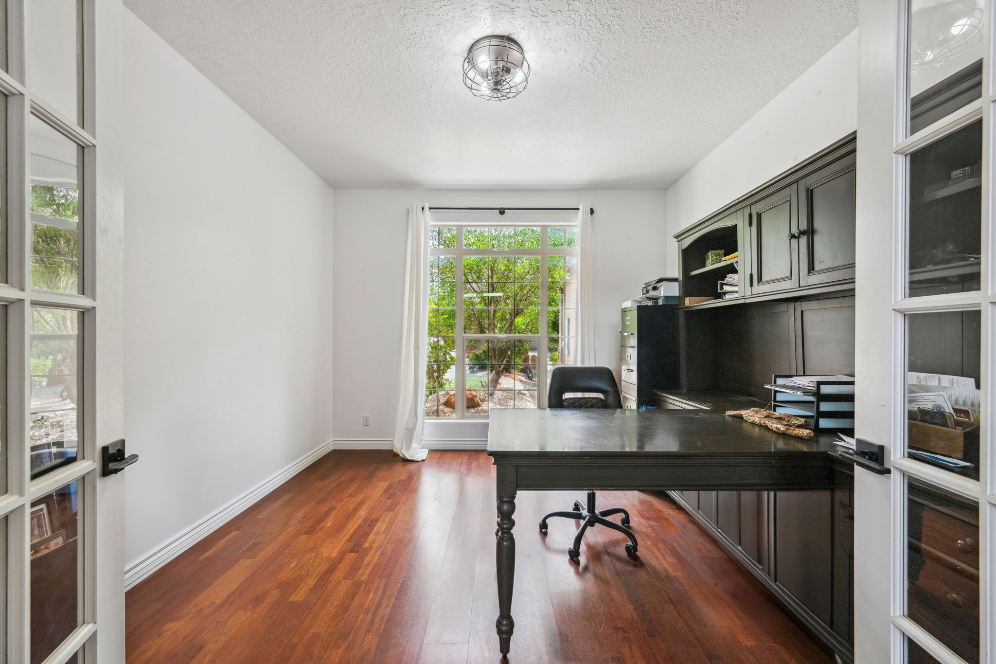 Office area featuring a textured ceiling and dark wood-type flooring