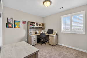 Bedroom featuring a textured ceiling and light carpet