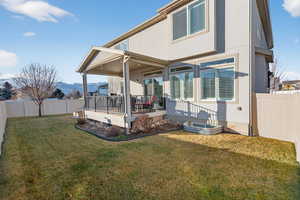 Rear view of property featuring a fenced backyard, stucco siding, and a mountain view