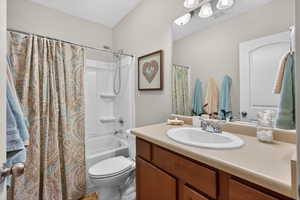 Bathroom featuring vanity and shower / bath combination with curtain