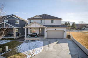 View of front of property featuring covered porch, stucco siding, concrete driveway, a garage, and a shingled roof