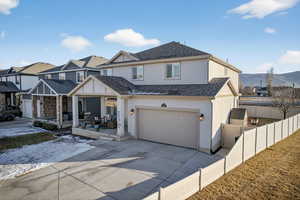View of front of home featuring covered porch, stucco siding, a shingled roof, an attached garage, and concrete driveway