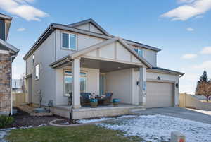 View of front of property featuring stucco siding, a porch, concrete driveway, and outdoor lounge area