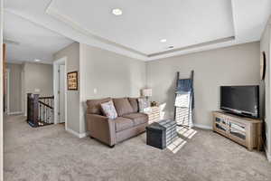 Loft/Living area with a raised ceiling, light carpet, recessed lighting, and a textured ceiling
