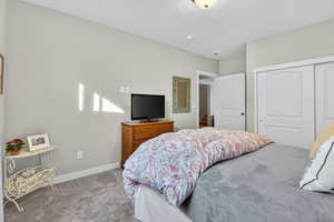 Carpeted bedroom with a closet and a textured ceiling
