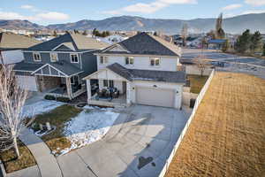 Back of property featuring stucco siding, a residential view, a mountain view, an attached garage, and driveway
