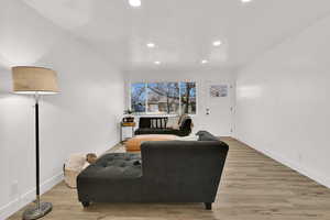 Living area with light wood-style flooring and recessed lighting