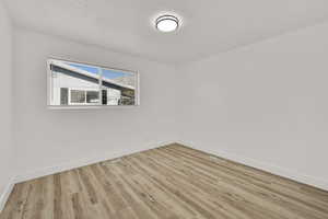 Spare room featuring light wood-style flooring and a textured ceiling