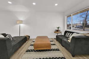 Living area with recessed lighting and light wood-type flooring