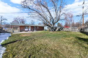 Back of property with a fenced backyard, a patio area, and brick siding